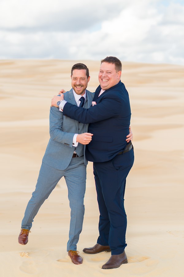 Tina and Stephen walking the Anna Bay sand dunes at Port Stephens overlooking the ocean, cinematic spring wedding portraits