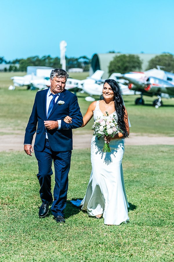 Rachel and Greg walking together across the iconic timber Luskintyre bridge in the Hunter Valley for their wedding portraits