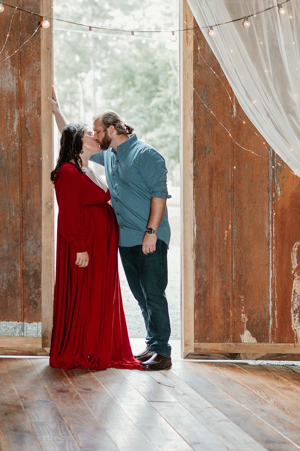 Mom and dad kissing inside the barn at Rustic Ridge, Deridder Louisiana