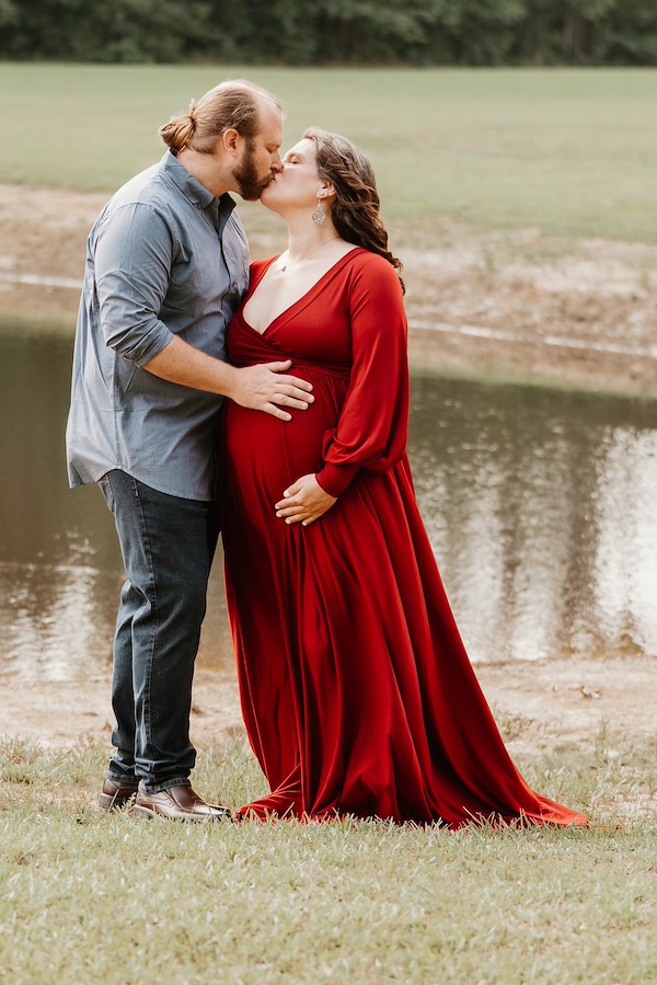 Mom and dad kissing in front of the pond at Rustic Ridge, Deridder Louisiana